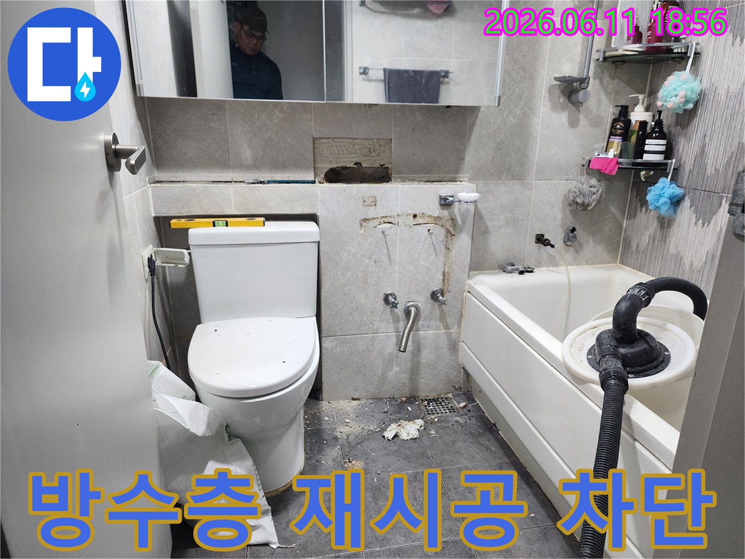 이 이미지는-서울 동대문구의 한 샤워실에서-누수 원인인 노후된 방수층을 교체하고-새로운 방수층을 시공하여-누수를 완벽하게 차단하는-작업 현장을 보여줍니다