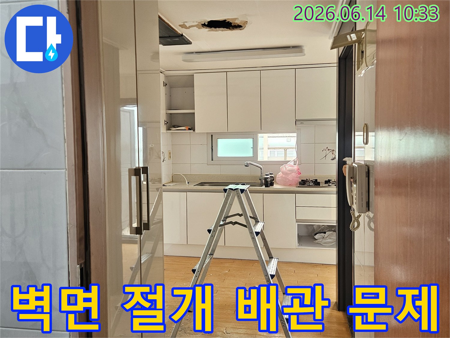 이 사진은-서울 동작구의 한 주방에서-배관 문제 해결을 위해-벽면을 조심스럽게 절개하는-공사 현장의 모습입니다