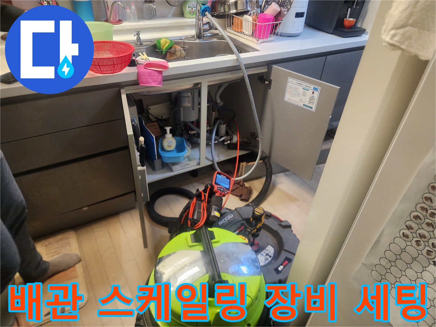 주방 싱크대 밑 배수관 내부 청소를 위한 전문 장비 배치 모습