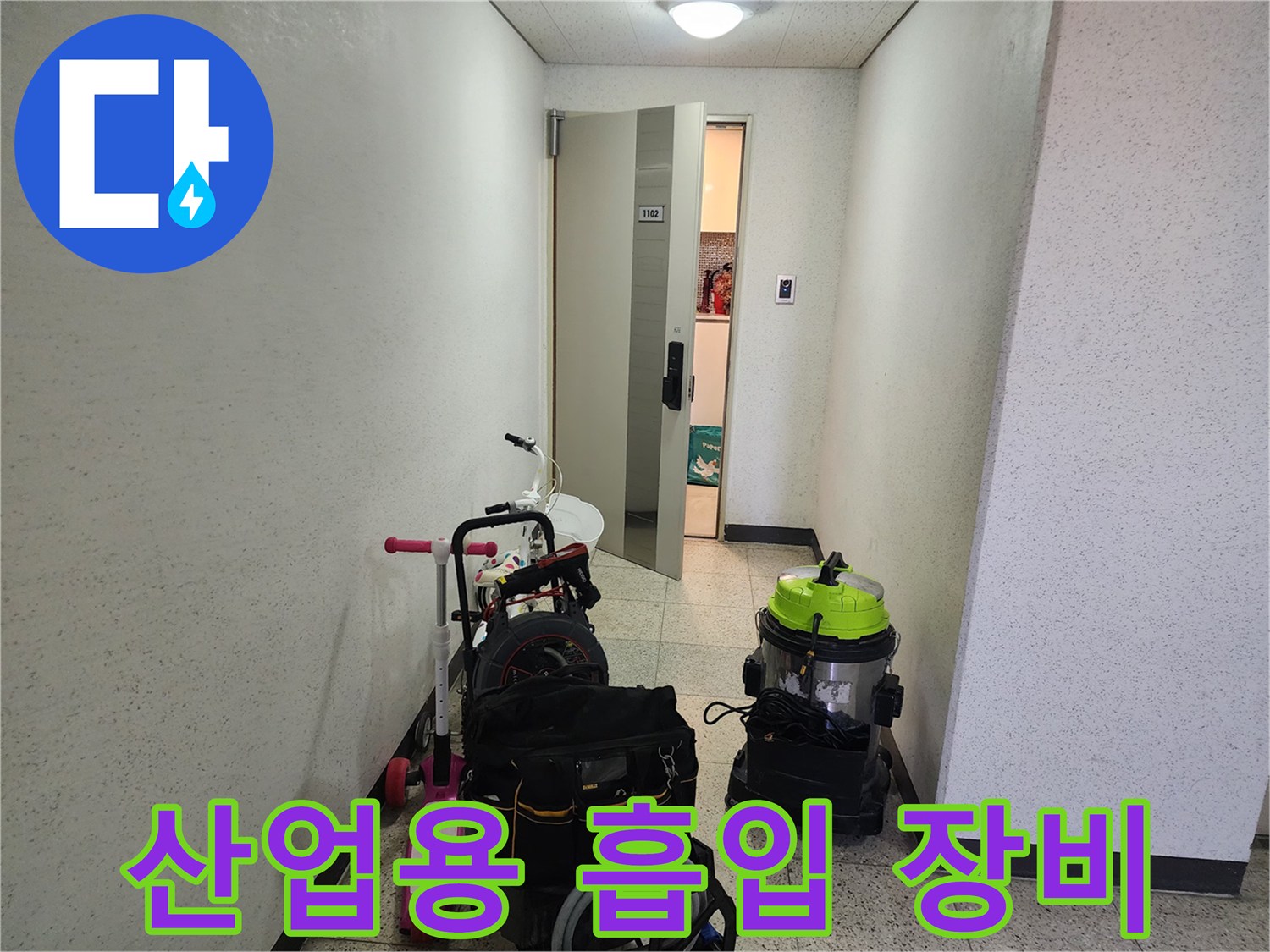 배관 세척을 위해 복도에 놓인 녹색 산업용 청소기