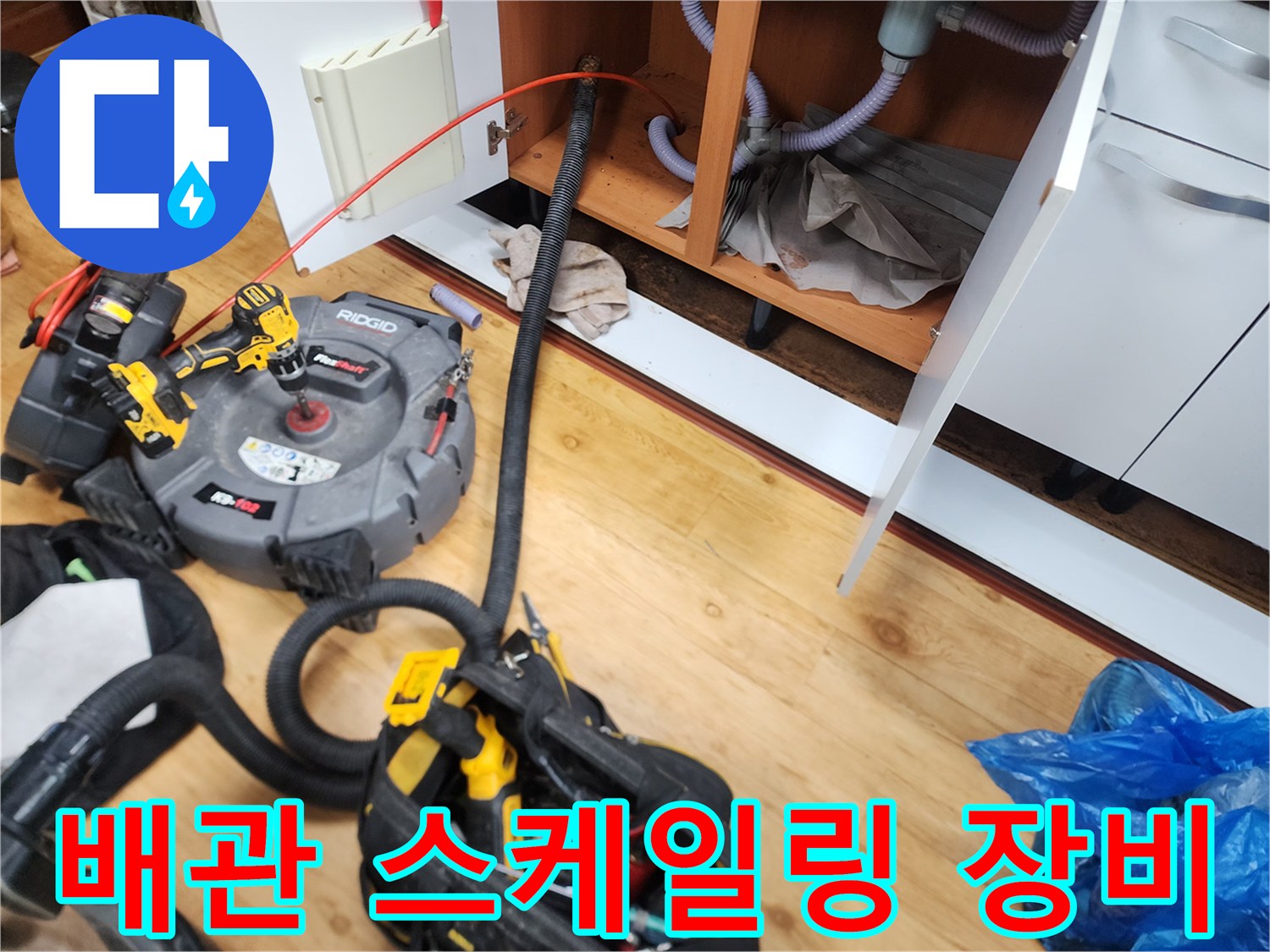 싱크대 하부 배수관 청소를 위해 준비된 리지드 전동 스프링 장비와 호스