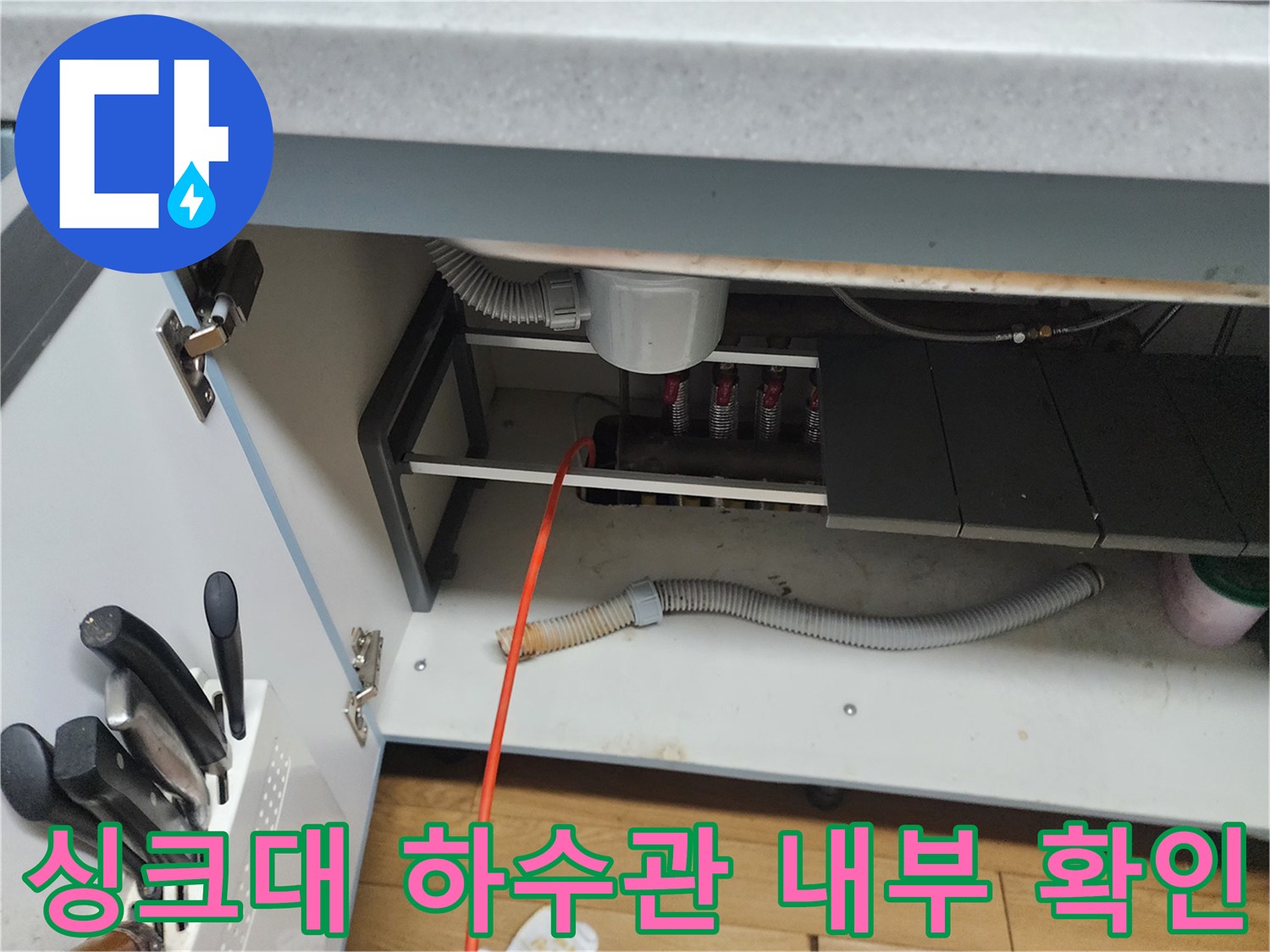 싱크대 아래쪽의 회색 배수 호스와 연결된 관 부위 촬영