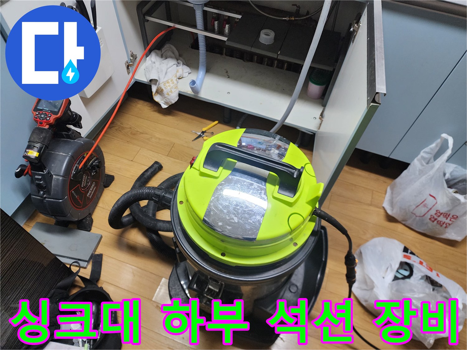 주방 싱크대 하부장 내부에서 사용 중인 강력한 석션기 모습입니다.