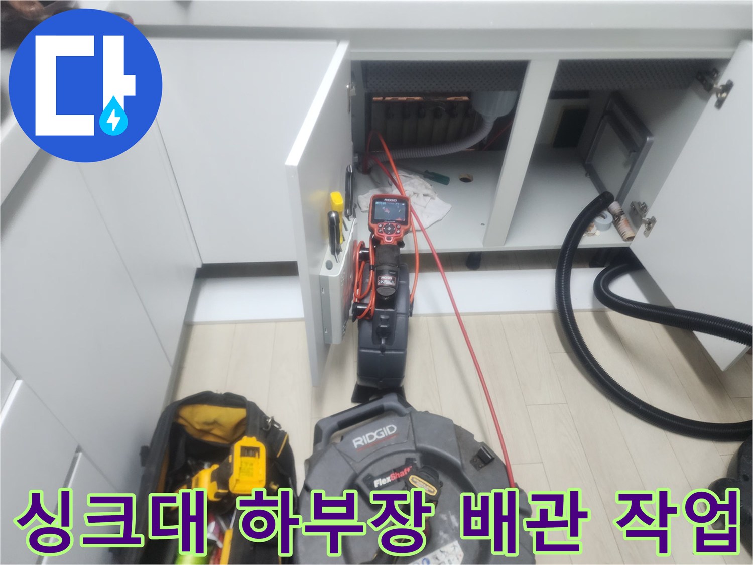 남양주 평내동 싱크대 하부장 내부에서 플렉스 샤프트 장비를 이용해 배관 스케일링 작업을 진행하는 모습입니다.