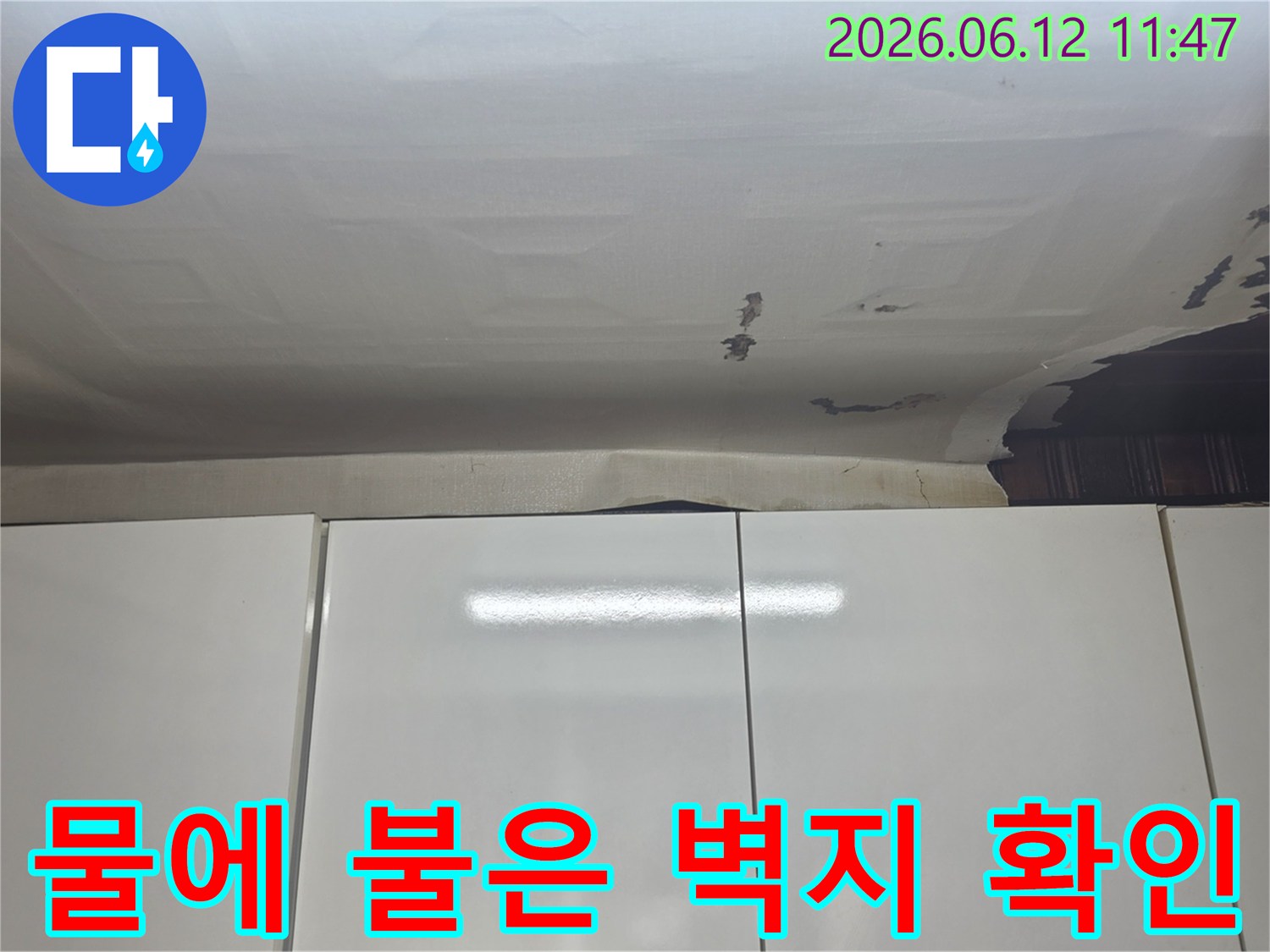 수진동 주택 천장-누수 흔적으로-벽지가 변색되고-손상된 것을-전문가가-점검하고 있습니다