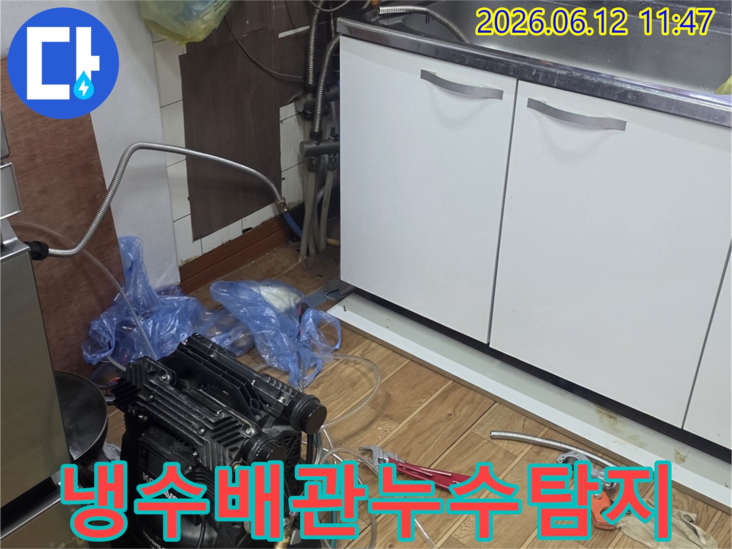 주방 싱크대 하부에서-냉수 배관 누수를 탐지하기 위해-전문 장비를 연결하고-점검하는 작업 현장