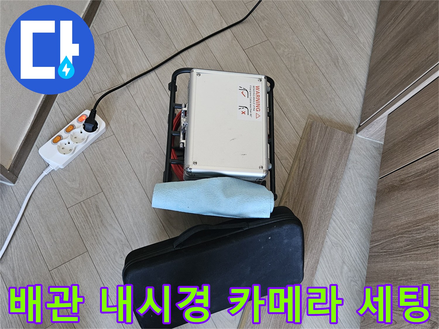 바닥 콘센트에 연결된 누수 탐지용 내시경 장비와 케이스