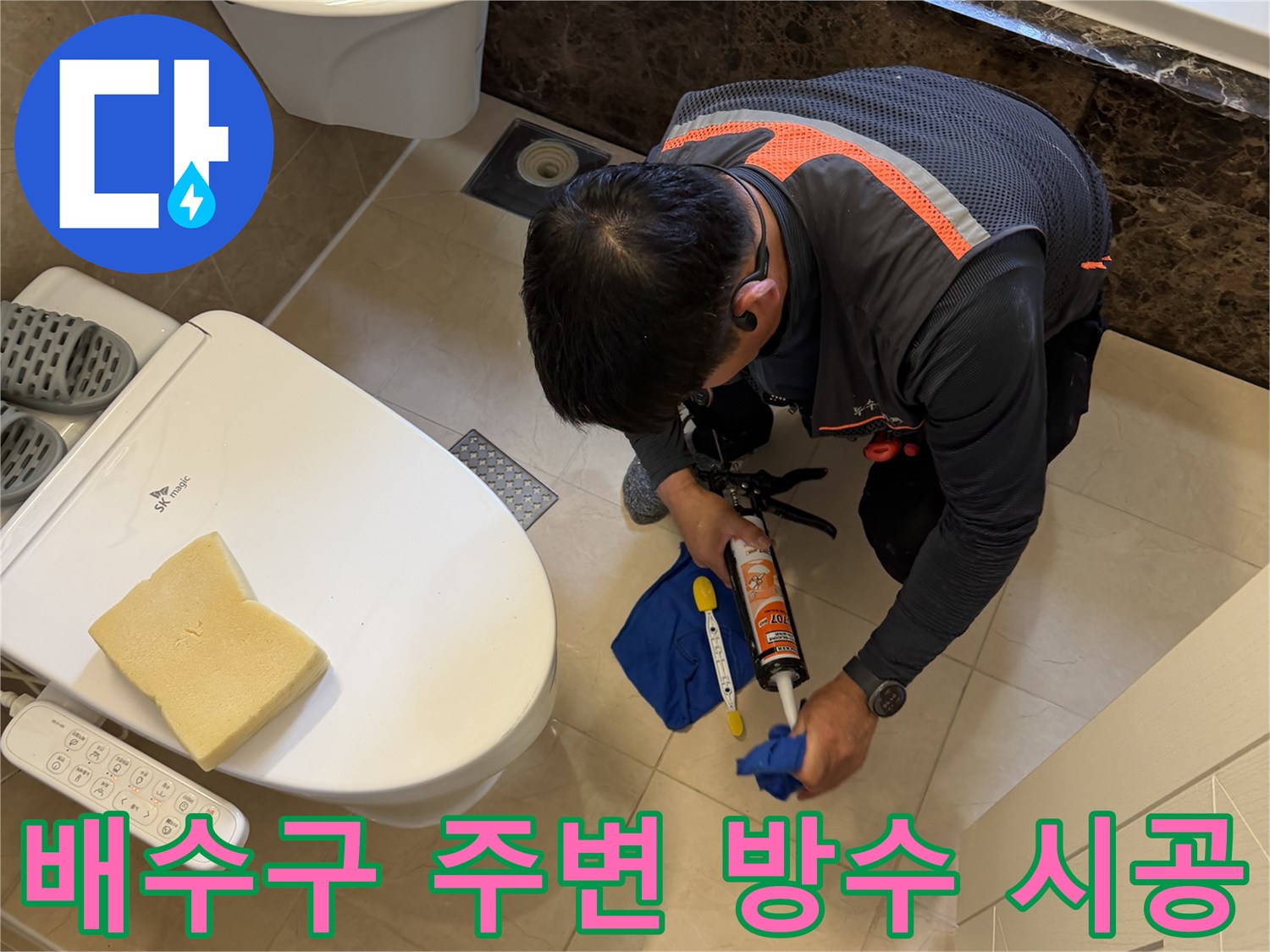 방수 실란트를 사용하여 변기 근처 배수구 틈새를 메우는 작업자
