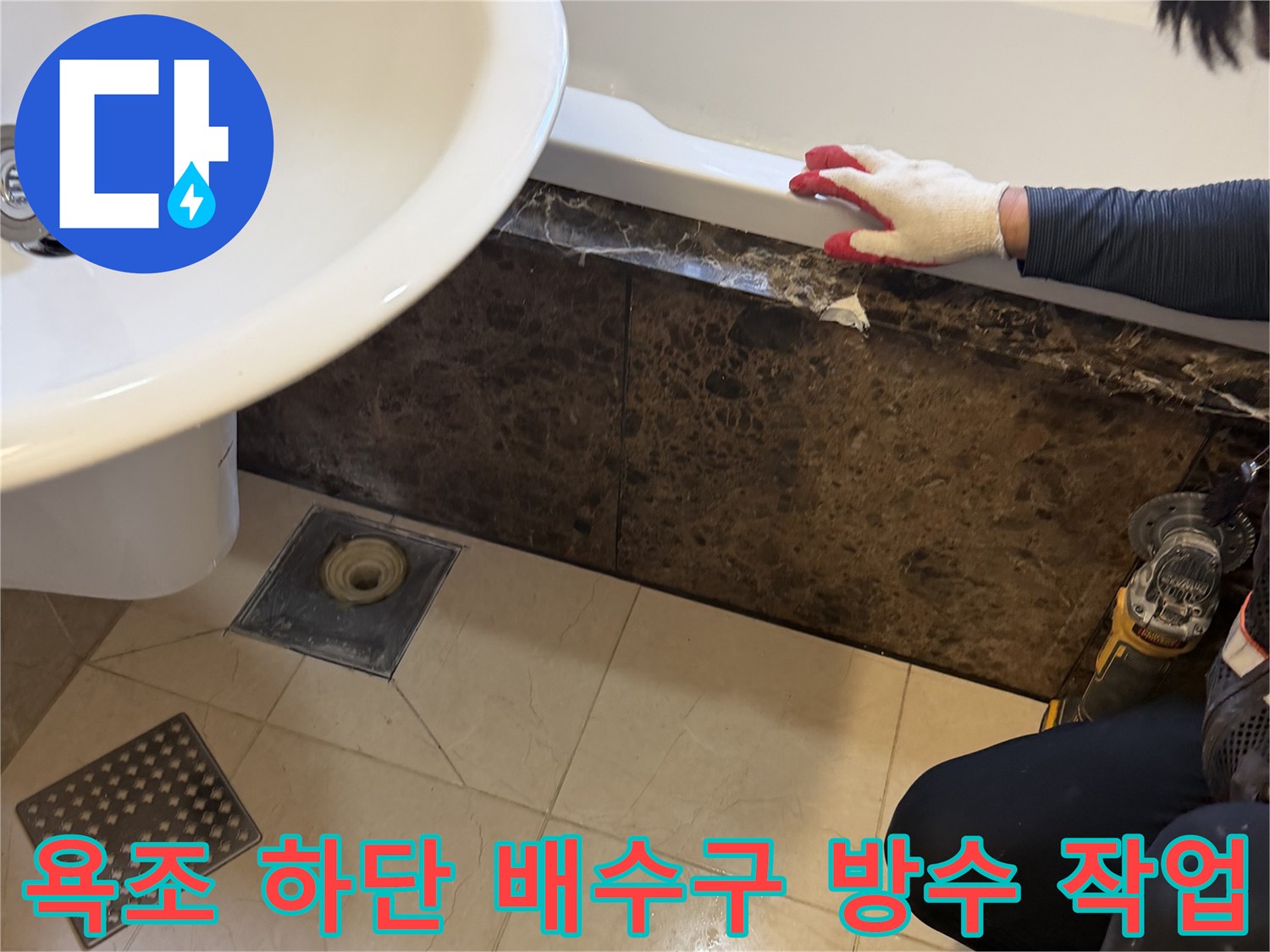욕조 하단 배수구 주변의 틈새를 메우기 위해 전문 장비를 사용하여 방수 보강 작업을 진행하는 모습입니다.