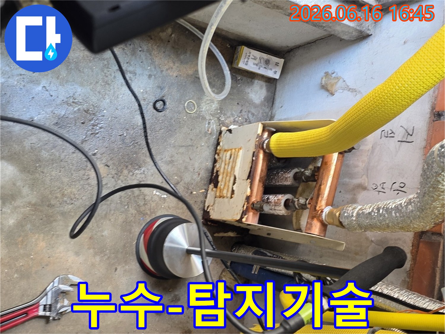 누수-전문-엔지니어가-청음식-탐지기로-누수-지점을-찾아내어-문제-해결의-첫걸음을-시작하는-모습