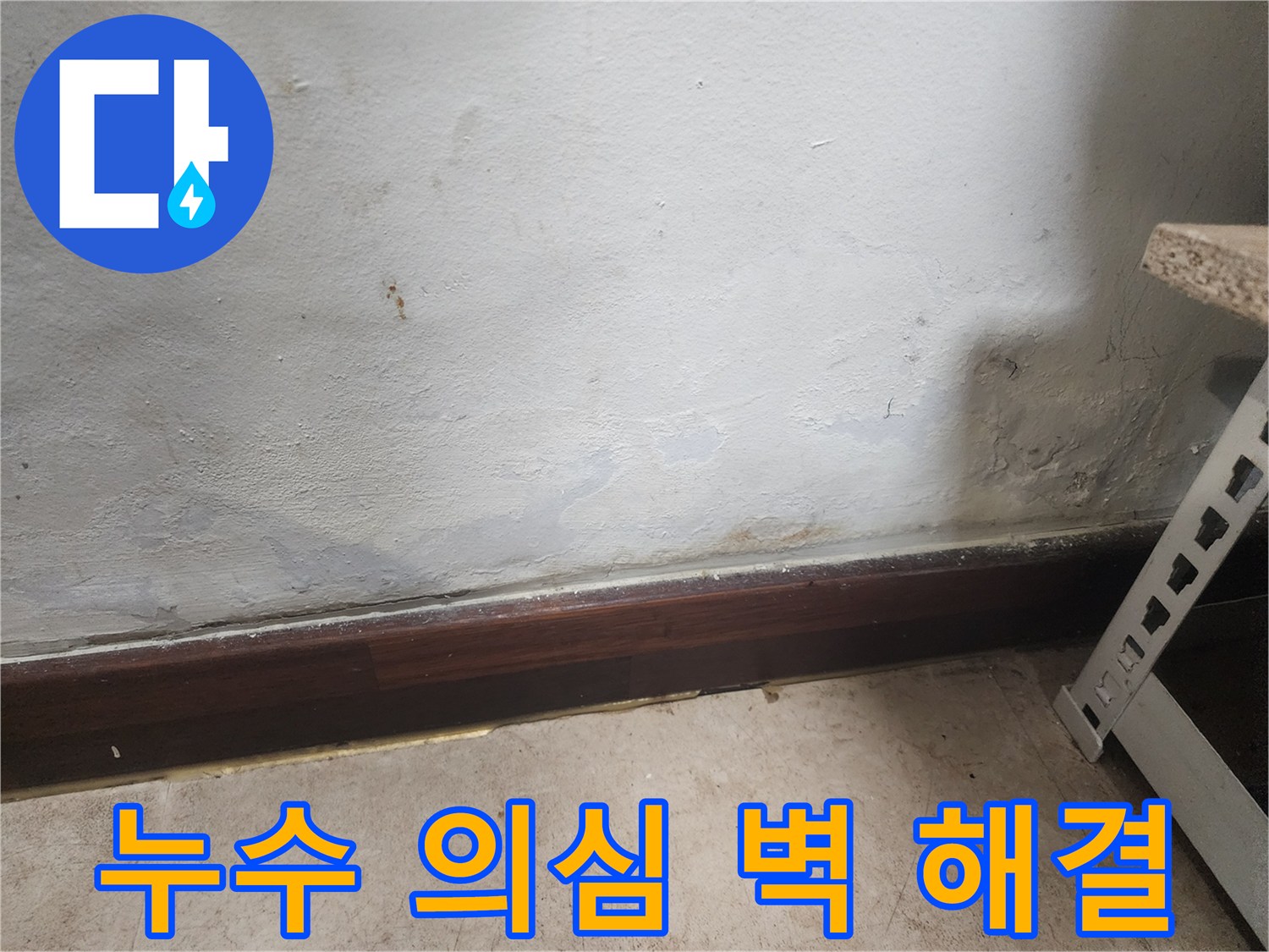 벽 하단부에 물이 스며들어 벽지가 젖고 곰팡이가 피어있는 누수 피해 현장 사진입니다.