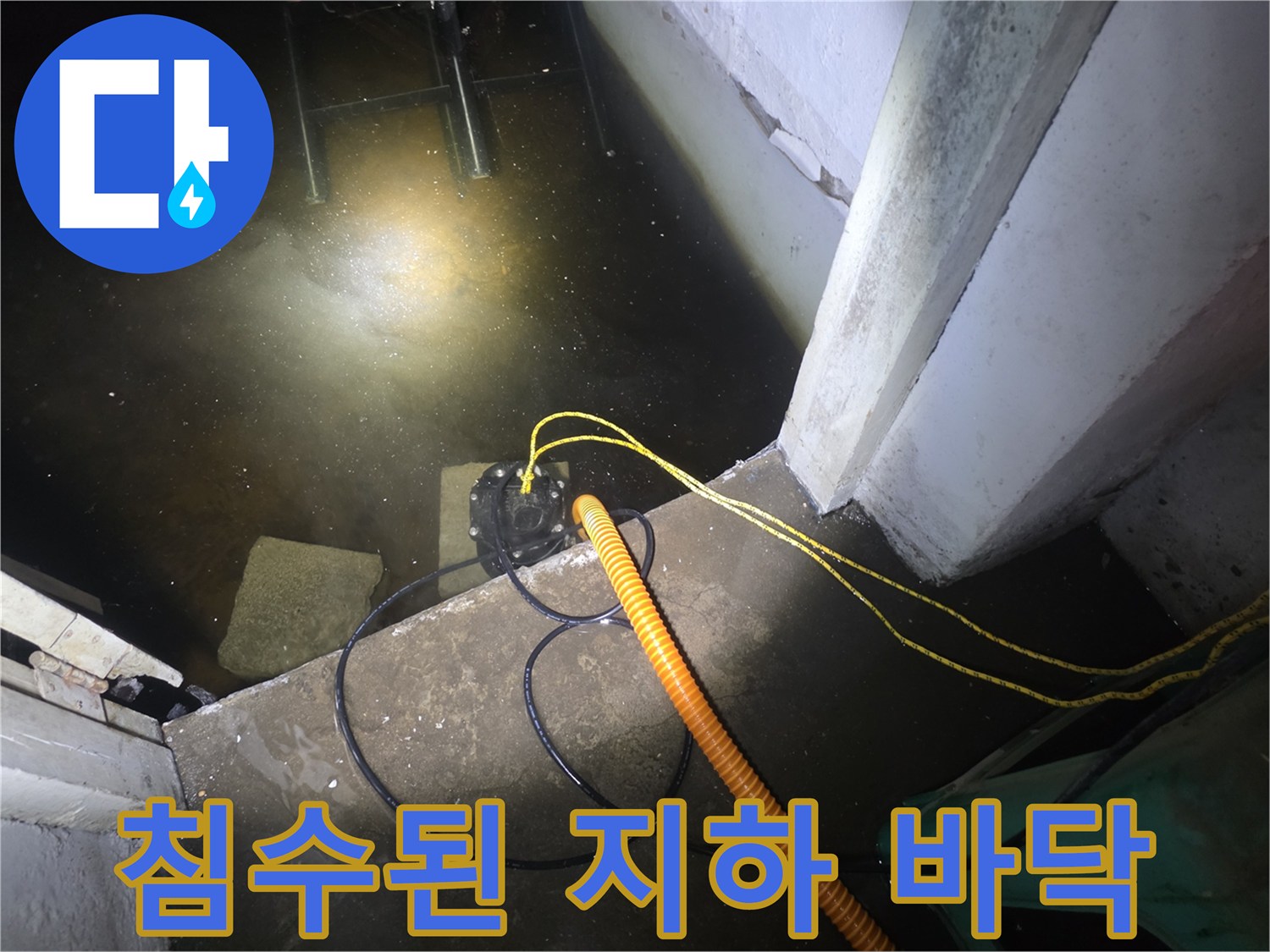 배수 호스가 놓여 있는 물이 가득 찬 어두운 지하 공간