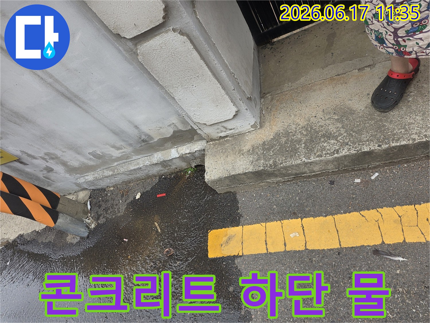 콘크리트-기초-아래에서-새어-나온-물이-도로-아스팔트-위에-고여있는-모습