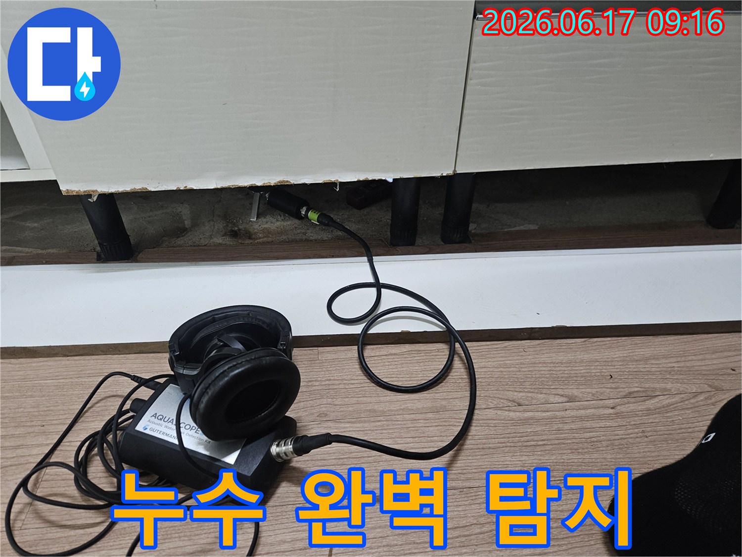 누수 탐지 엔지니어가-첨단 청음식 장비를 사용하여-싱크대 하부의 누수 지점을 완벽하게 탐지하는 모습