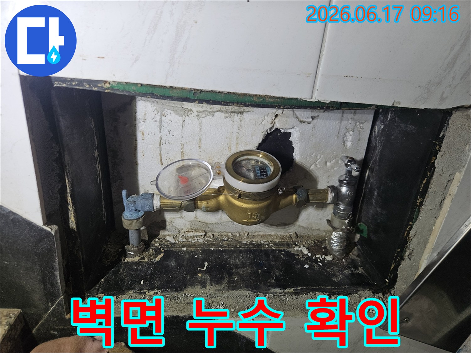 수도계량기-설치된-벽면에서-발생한-누수-징후를-세밀하게-관찰하는-모습입니다