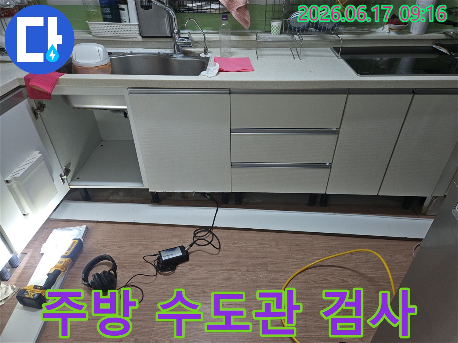 주방 배관 터짐으로 인한-긴급 누수 현장에서-전문 장비를 사용하여-수도관 상태를 정밀하게 검사하는 모습