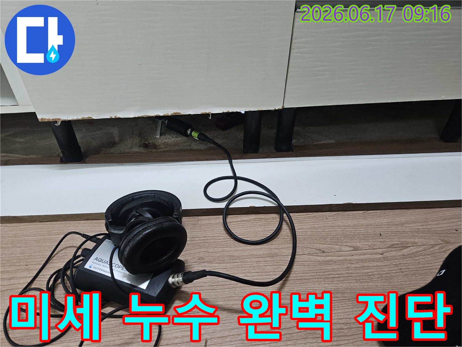 청음식 누수 탐지 장비의 센서가-싱크대 하부장 틈새에 삽입되어-미세한 누수음을 감지하는 모습