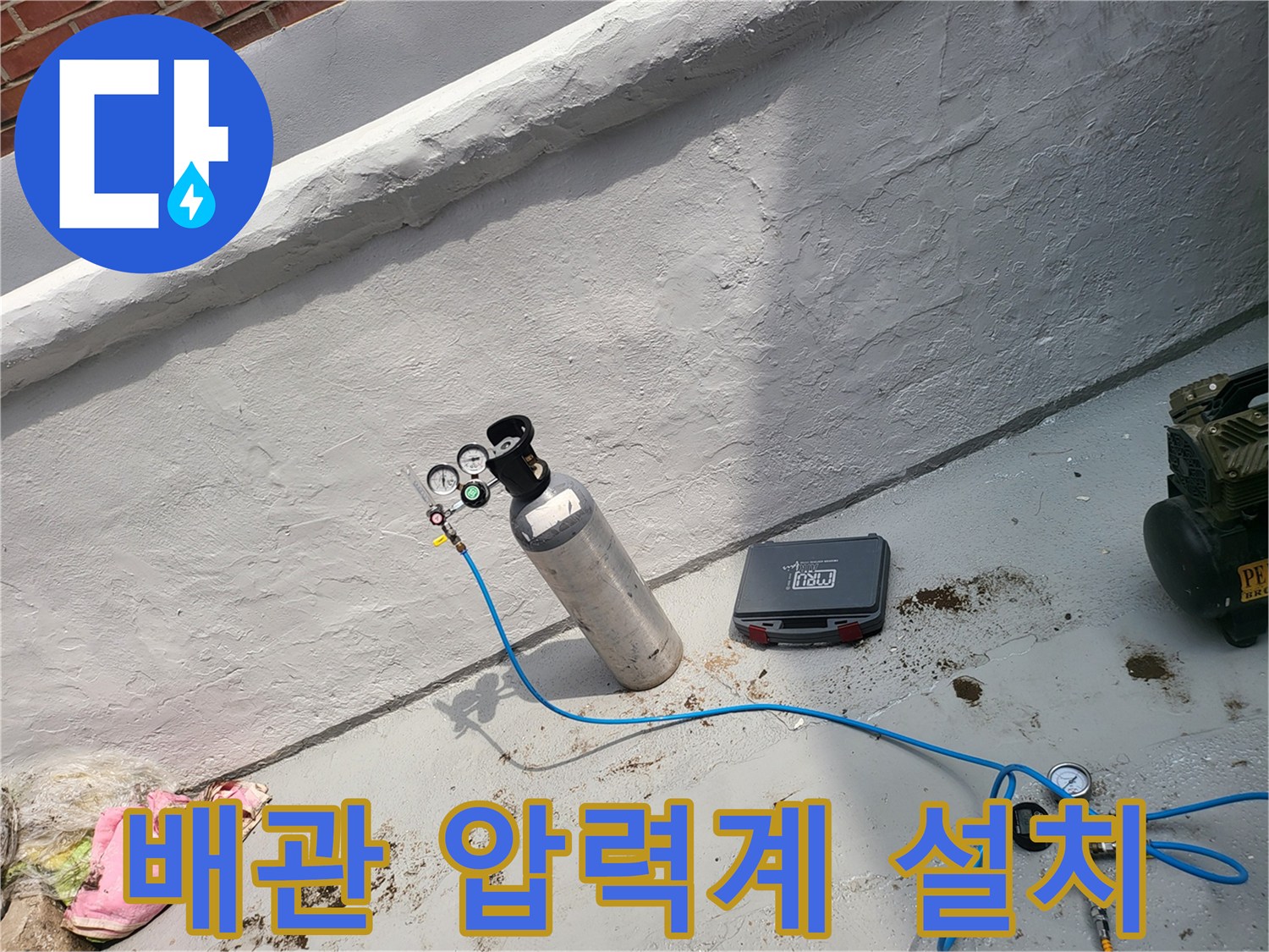 가스통에 연결된 압력 게이지와 파란색 호스-배관 압력 확인 중