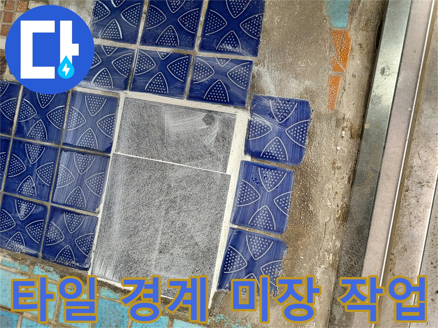 파란 타일과 회색 타일 사이의 시멘트 마감 부위