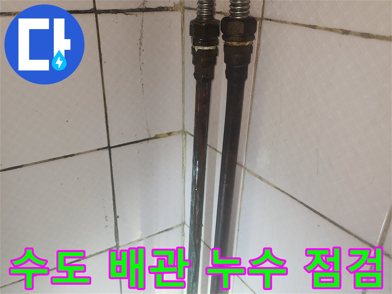 오래된 수도 배관의 연결 부위와 주변 타일의 상태를 보여주며-누수 점검 과정을 나타냅니다