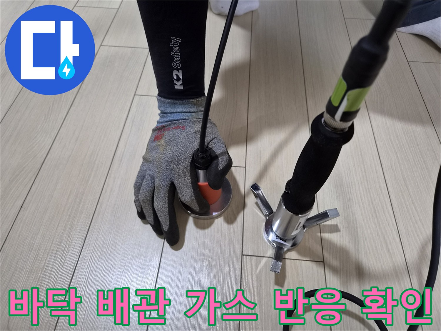 가스 탐지기를 마루 바닥에 대고 누수 지점을 찾는 전문적인 작업 모습
