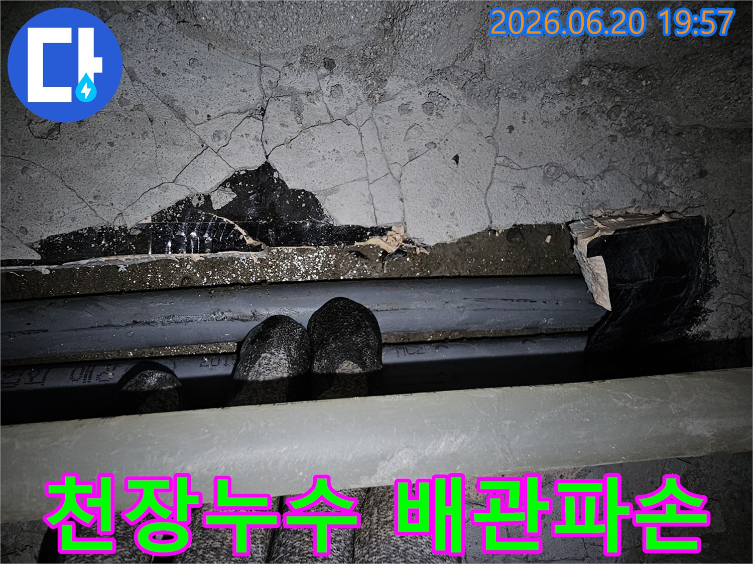 이 이미지는-오래된 건물 천장에서-누수가 발생하여-콘크리트가 손상되고-배관이 노출된-심각한 상황을-보여줍니다