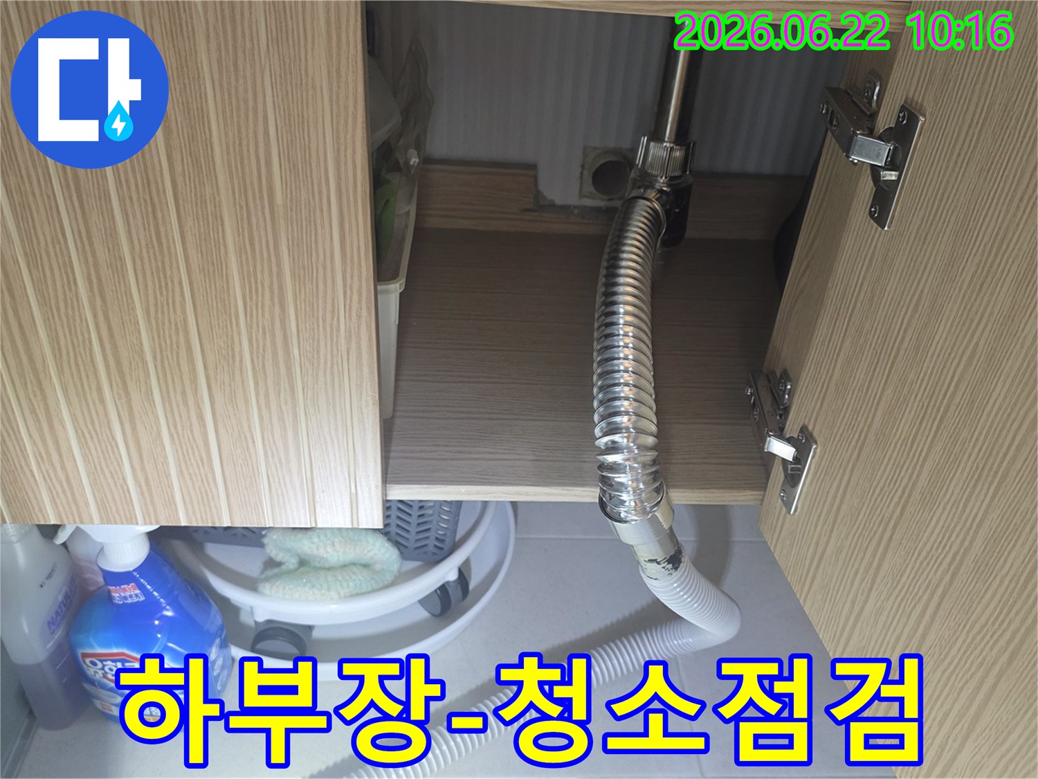 싱크대 하부장 내부를 청소하며-누수 흔적이나 잠재적인 문제점을 함께 점검하는 모습