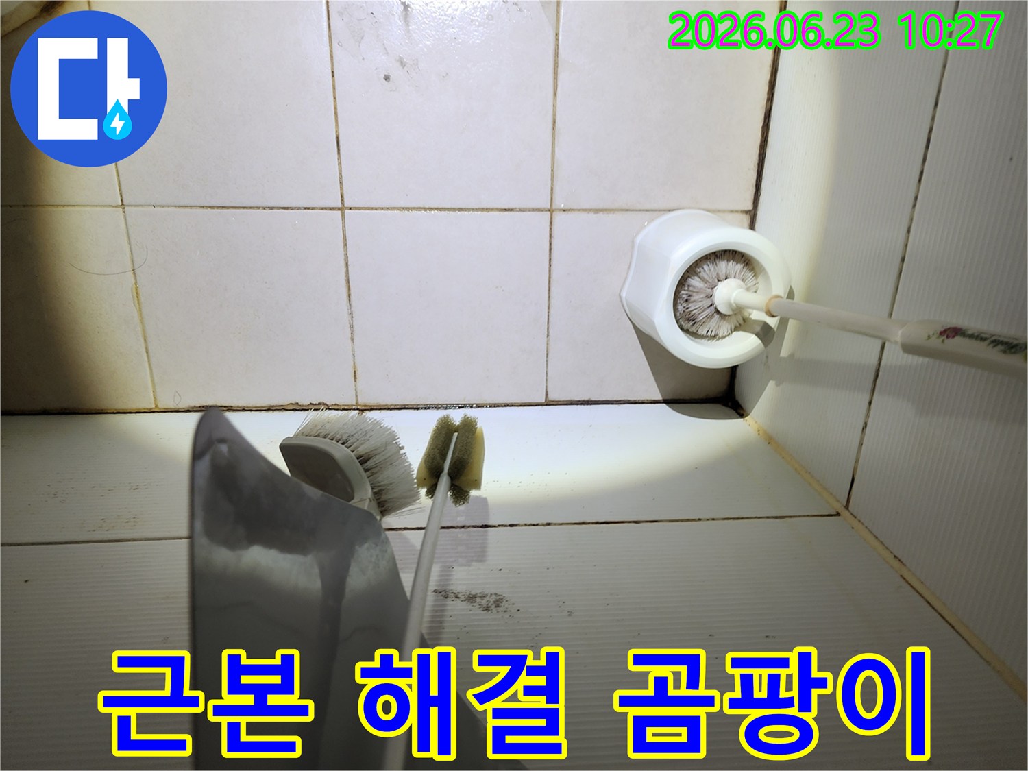 이 이미지는-욕실 바닥 타일의-줄눈에 생긴-검은 곰팡이와-오염된 청소용품-주변을-보여주며-누수 문제의-근본적인 해결의-필요성을-시사합니다.