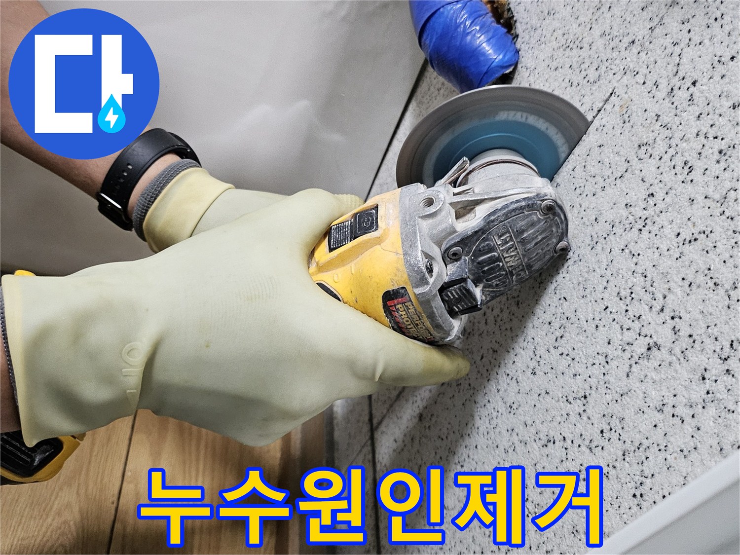 안전 장갑을 착용한 작업자가-그라인더로 천장 타일을-조심스럽게 절단하고 있습니다.