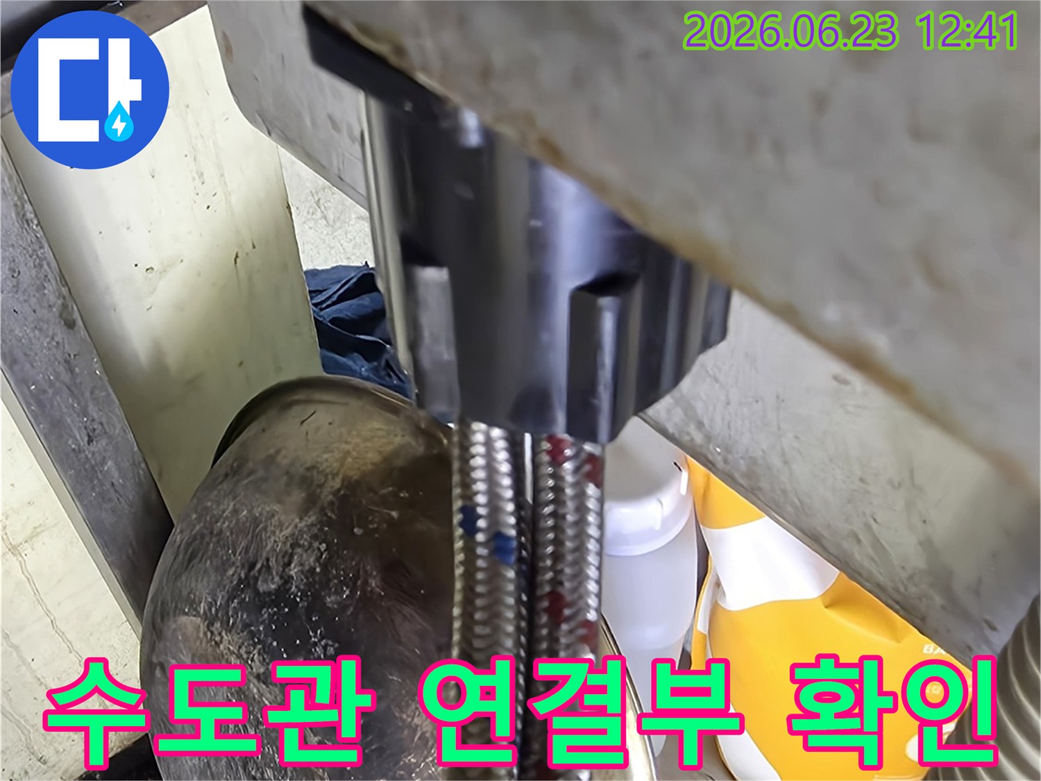 수도-배관-누수-의심-현장에서-전문가가-유연한-호스와-고정된-배관의-연결-상태를-확인하며-물샘-지점을-파악하는-모습입니다-이는-정확한-수리-계획의-기초가-됩니다