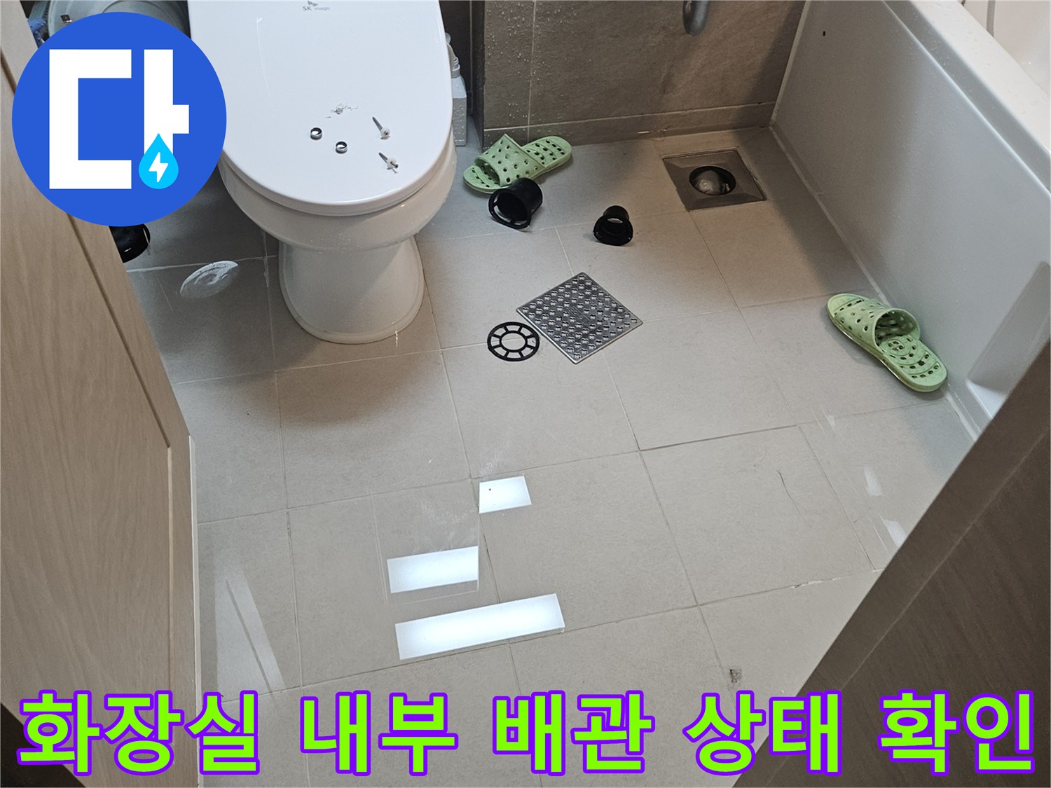 세면대와 변기 주변의 물샘 흔적을 조사하는 공사 현장