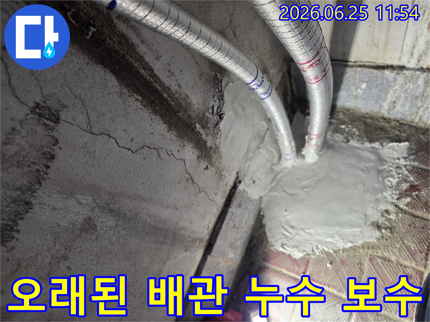 누수 전문가가 오래된 배관에서 발생한 누수 지점을-완벽하게 보수하는 모습입니다-벽면의 짙은 얼룩이 누수의 흔적을 보여줍니다.