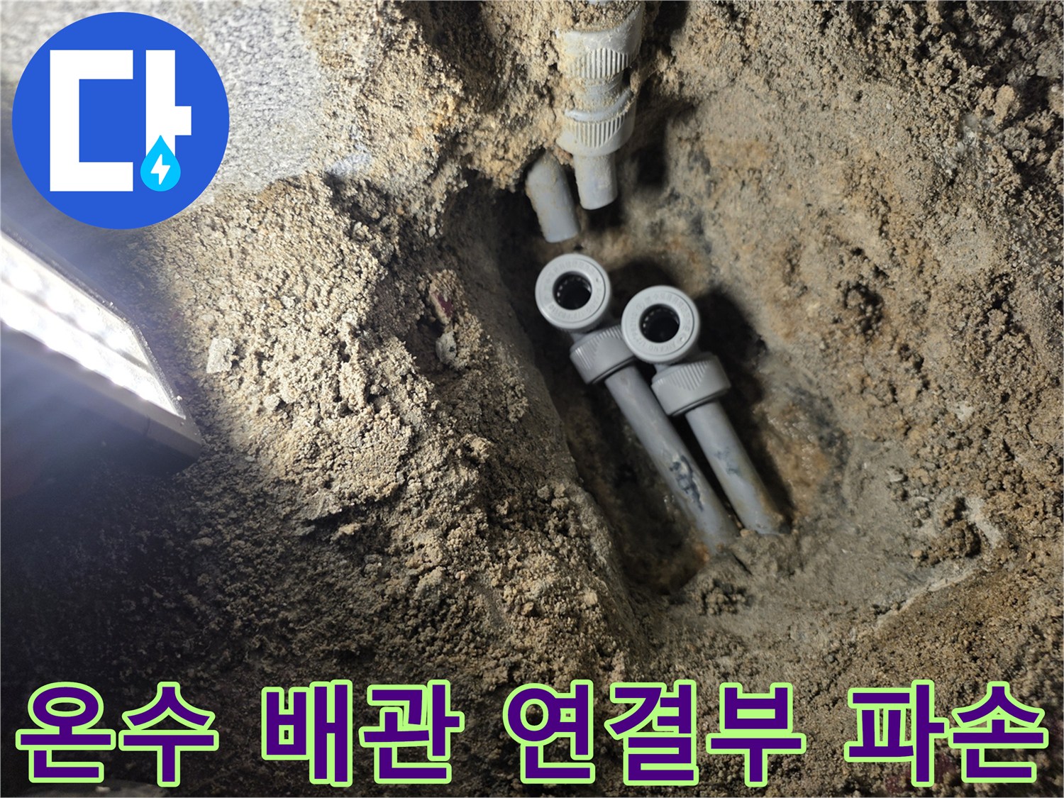 물에 젖은 흙과 함께 드러난 손상된 온수 배로 부속들