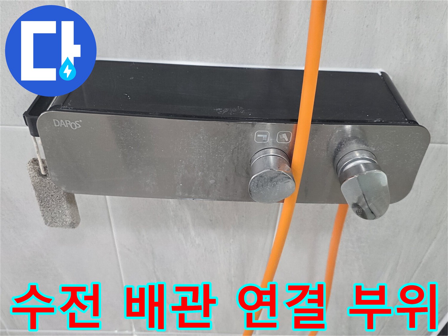 벽면에 고정된 수전 밸브와 주황색 호스 연결 상태