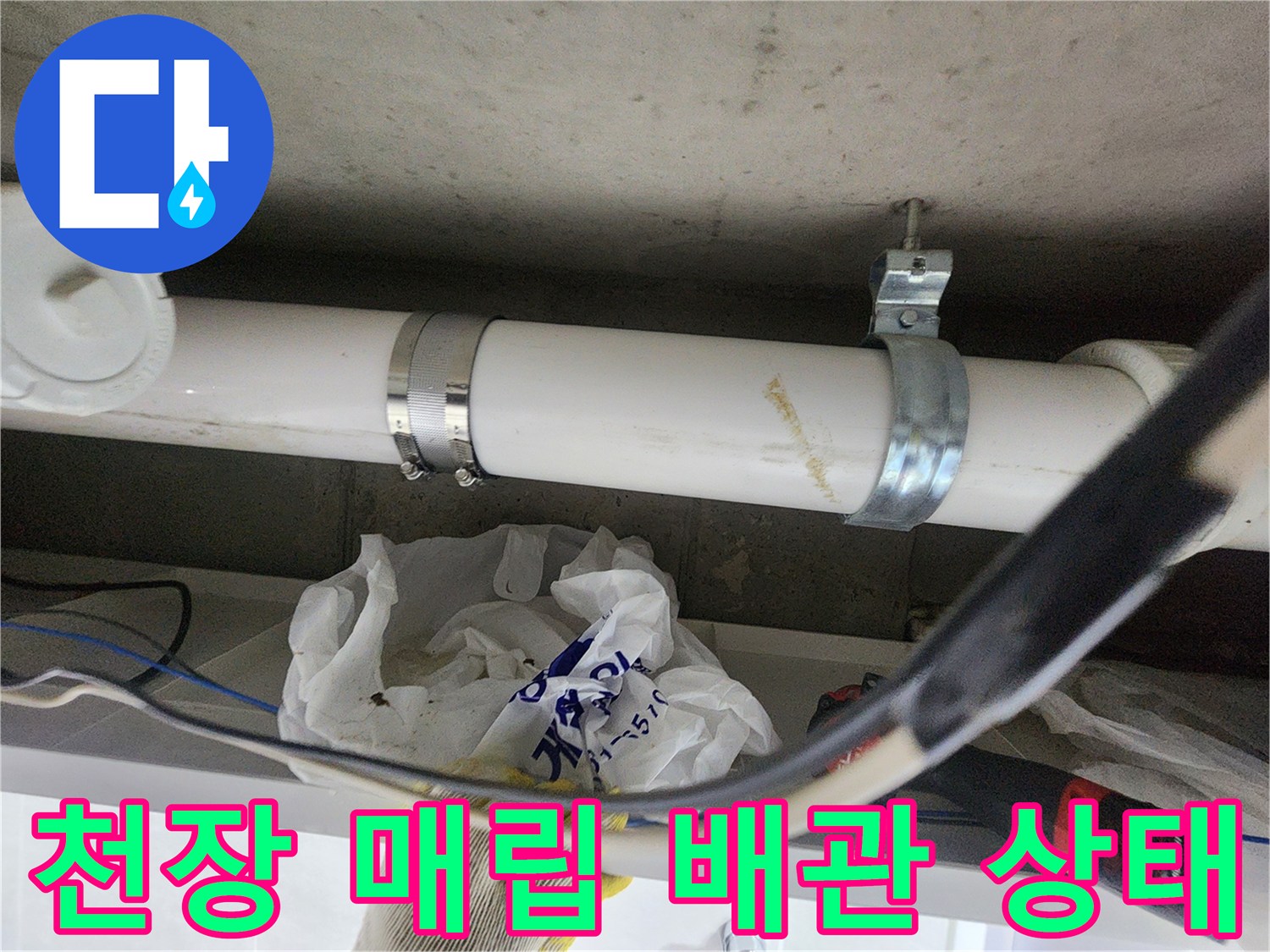 천장에 설치된 흰색 배관과 금속 고정 클램프 상세