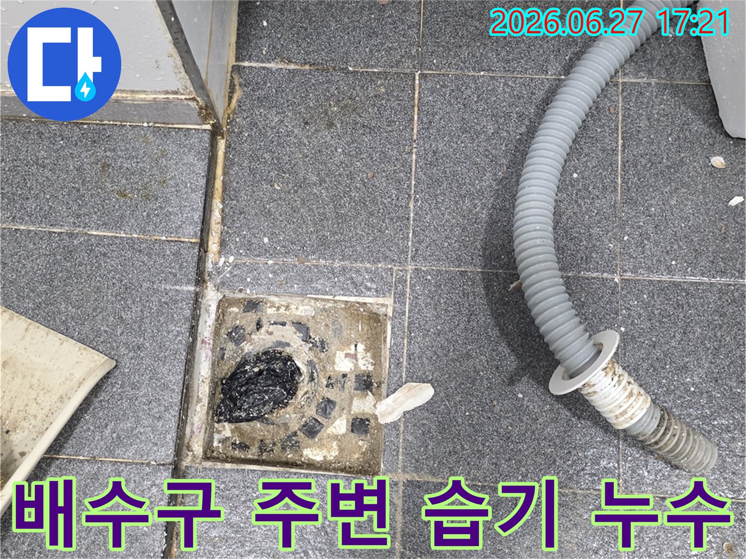 세탁실 바닥 배수구 주변에-지속적인 습기가 감지되어-누수 가능성을 보여주는-현장 사진입니다