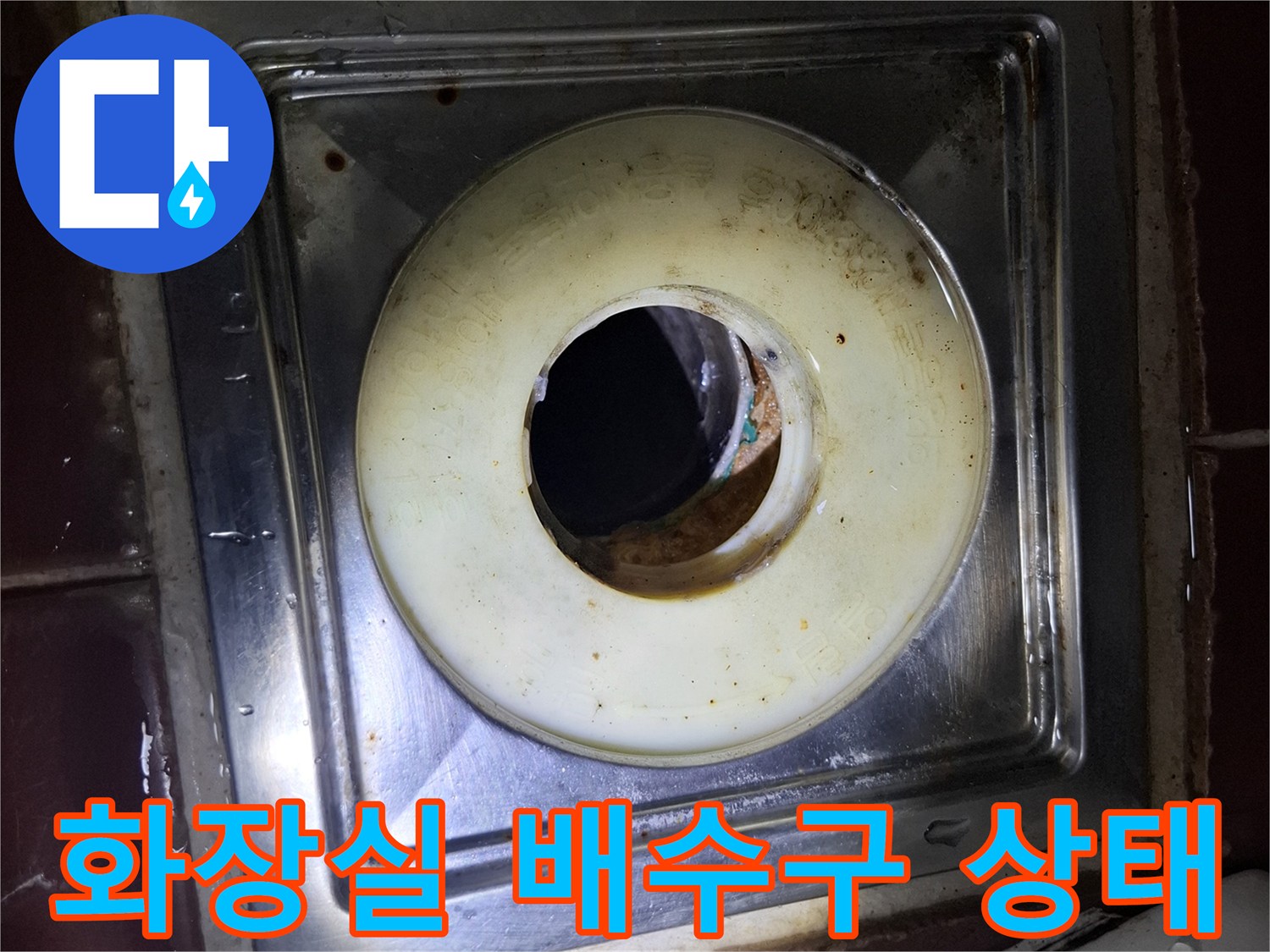 변기 하단 스테인리스 배수구 주변의 오염과 습기 상태를 보여줍니다