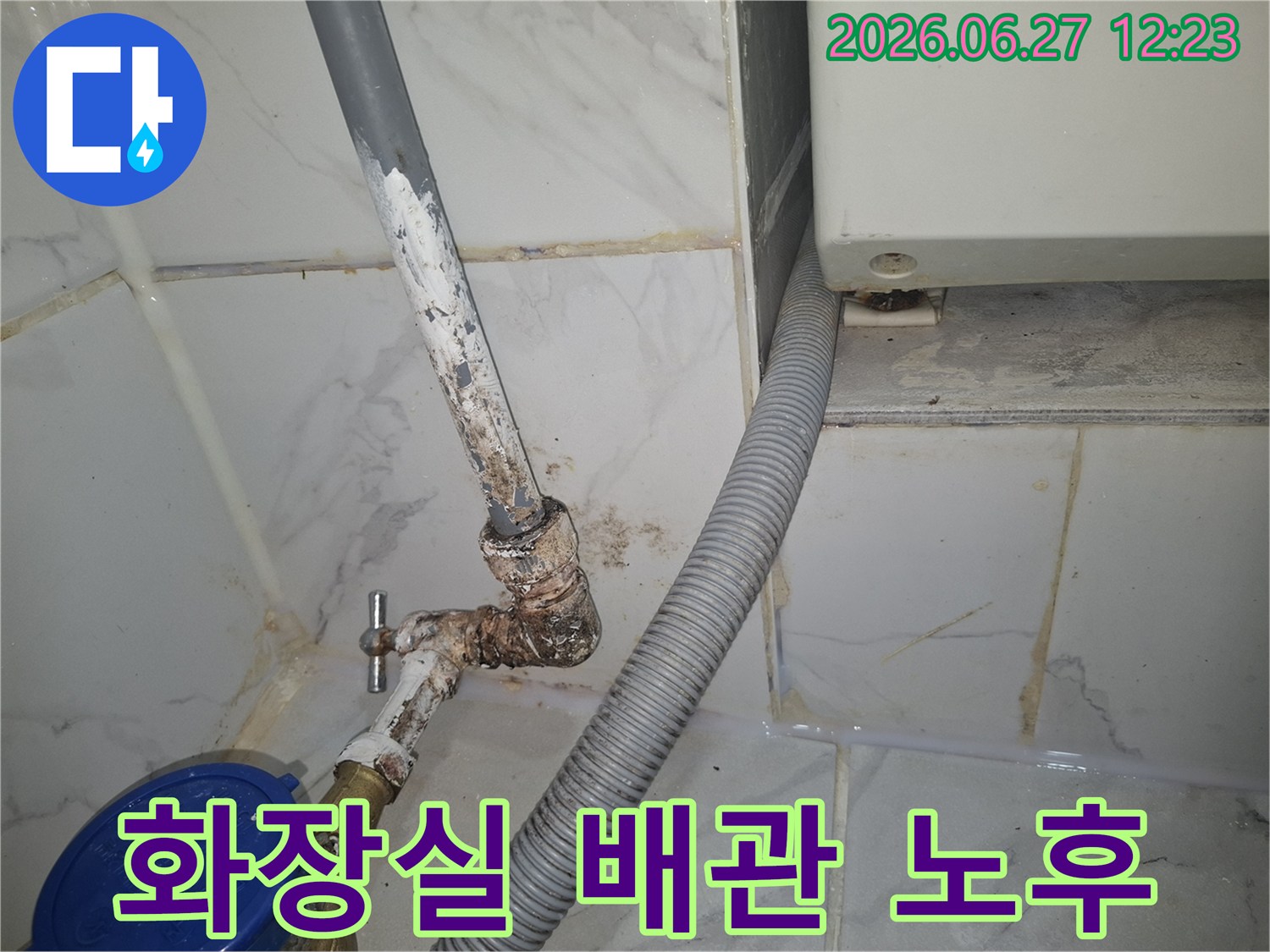 용산 이촌동 시범아파트의-화장실에서-발견된-오래된 배관의-부식 상태를-전문가가-자세히-살펴보고-있습니다