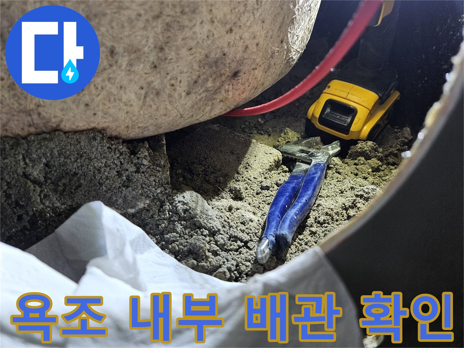 욕조 옆면을 타공하여 내부의 누수된 배관 상태를 점검하는 모습