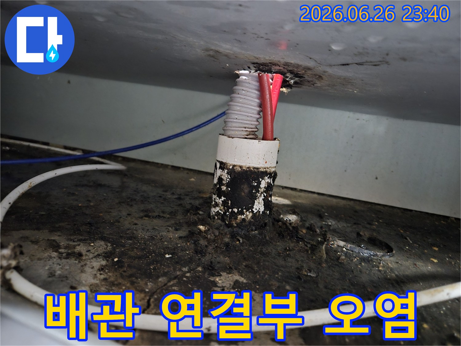 상가 건물 내부의 배관 연결부에서 발생한 누수로 인해-주변이 심하게 오염된 모습을 보여줍니다.