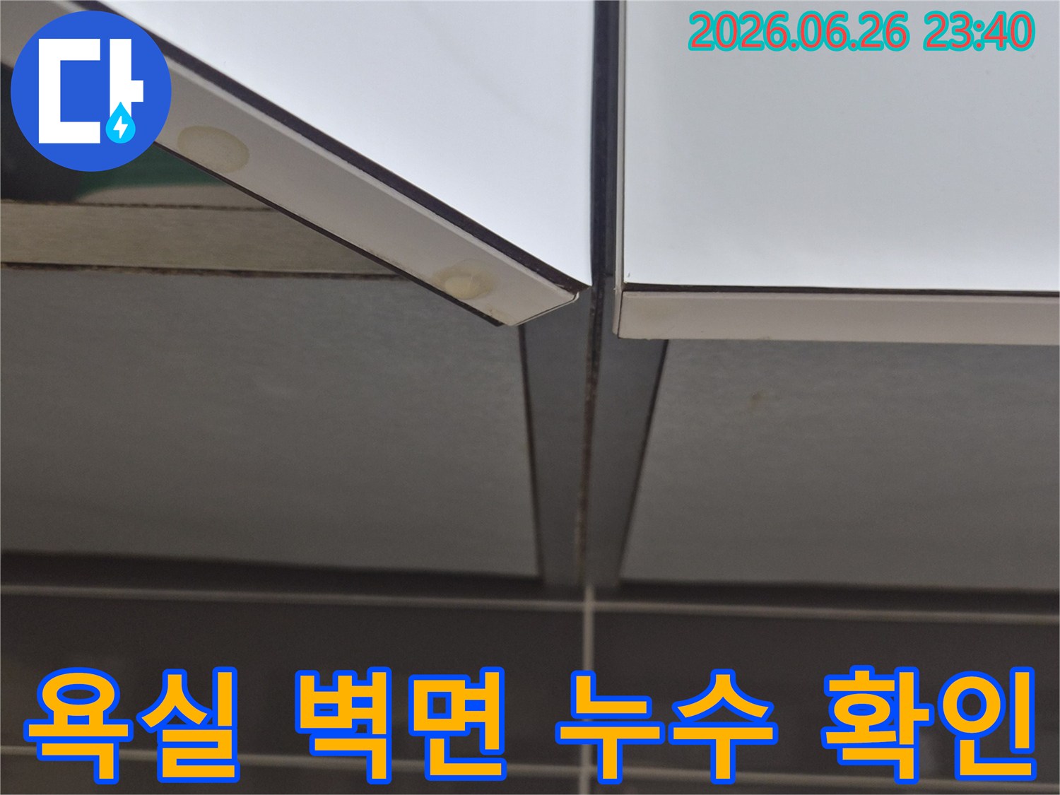 욕실-벽면-타일과-거울-경계에서-발견된-누수-의심-부분을-확대하여-보여주는-사진