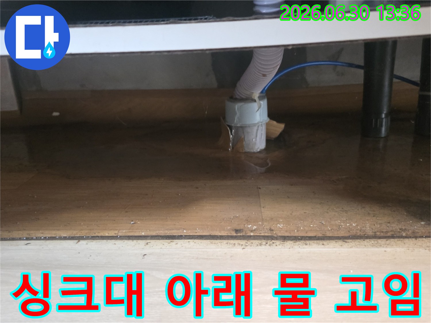 싱크대 하부에서 물이 새어 나와-바닥에 고여있는-누수 현장의 클로즈업 사진입니다.