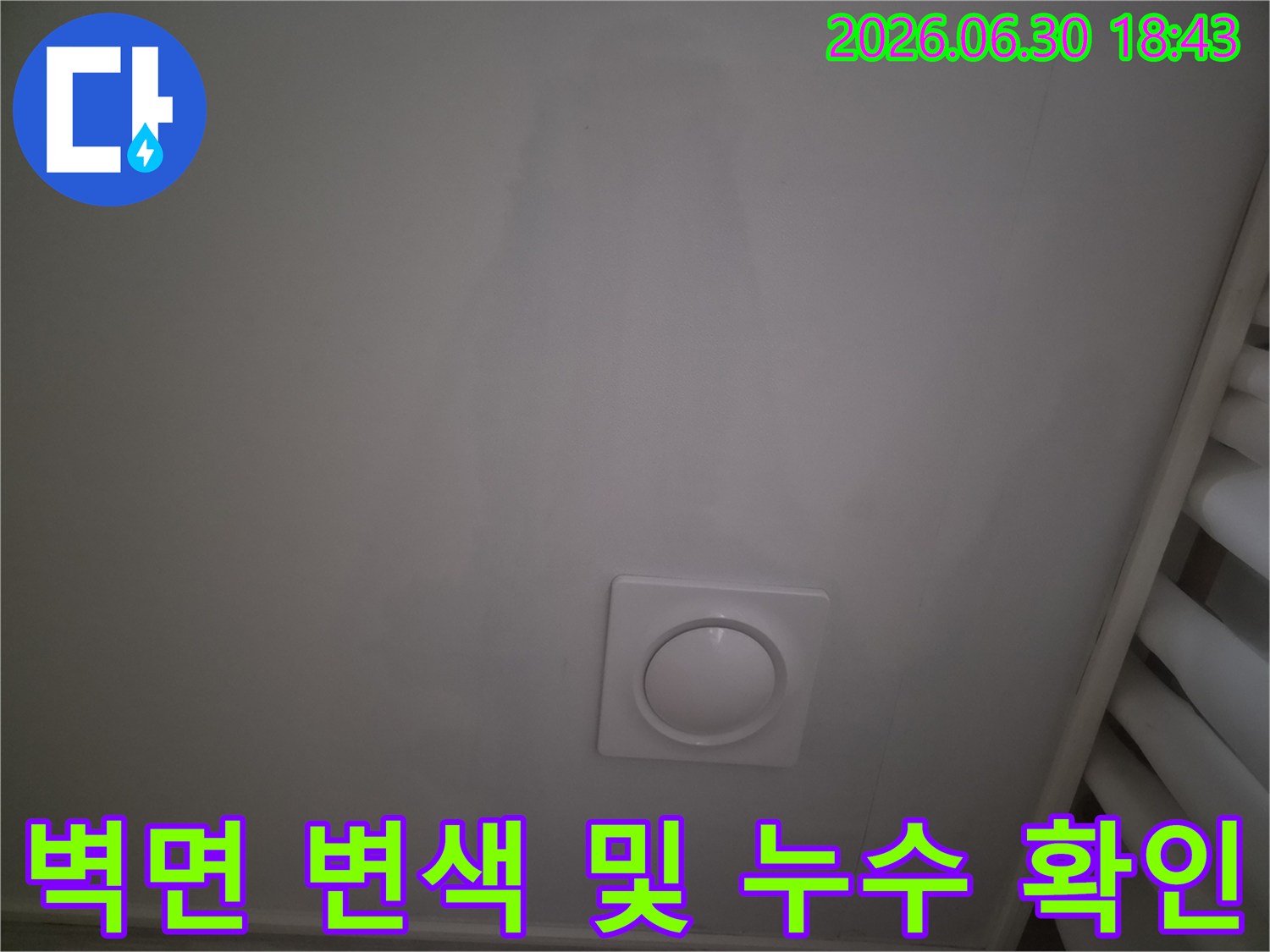 하얀 벽체에 형성된 누수 얼룩과 원형 배기구 사진