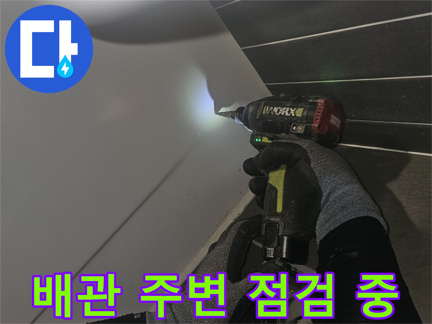 전동드릴로-배관-주변의-이물질을-정리하고-상태를-살피는-장면