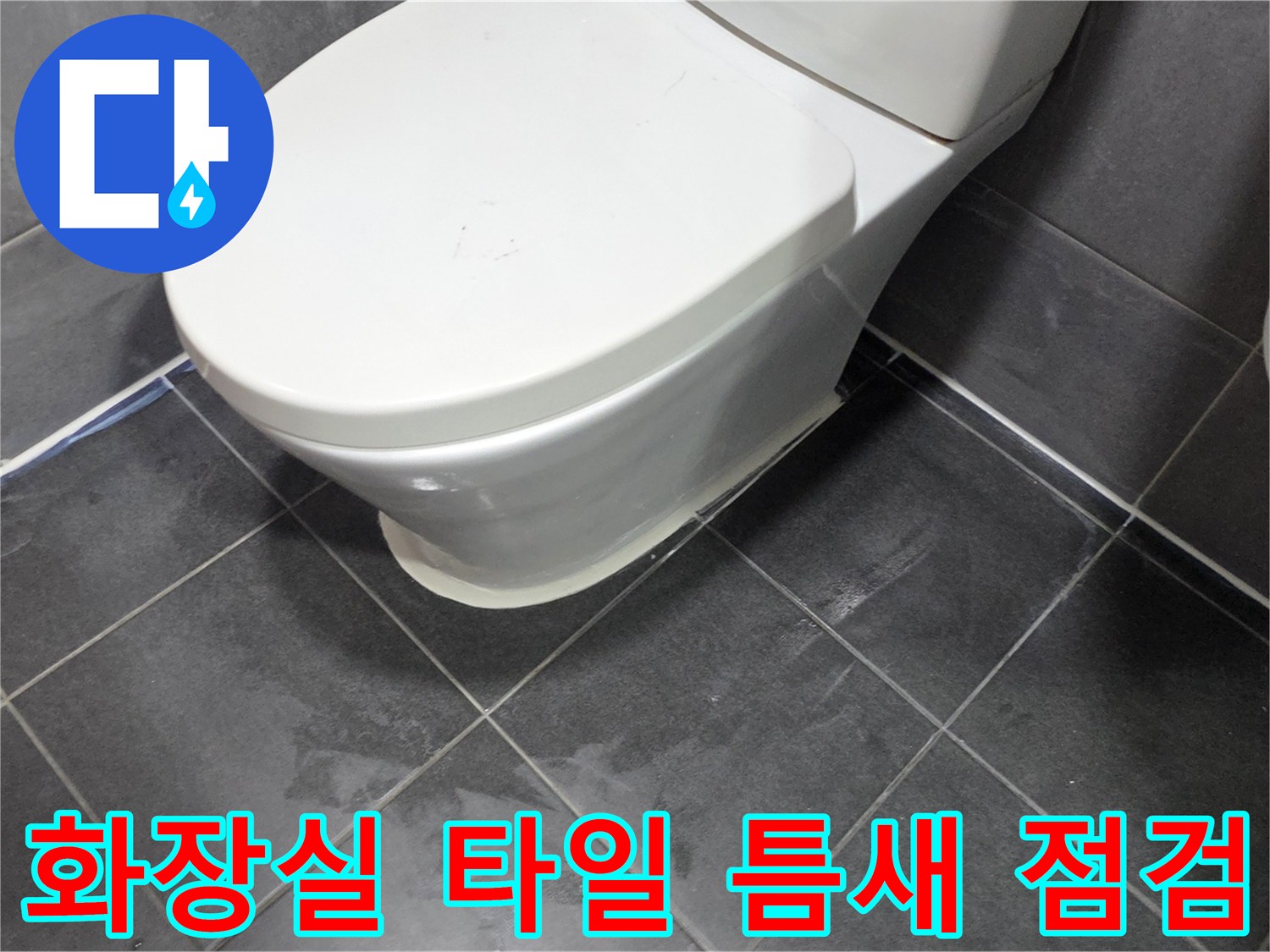 변기 주변의 어두운 색조 타일과 메지 상태를 보여주는 사진