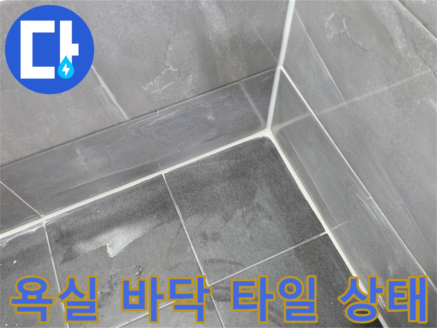 어두운 회색 욕실 타일과 줄눈 사이의 습기 상태를 보여주는 사진