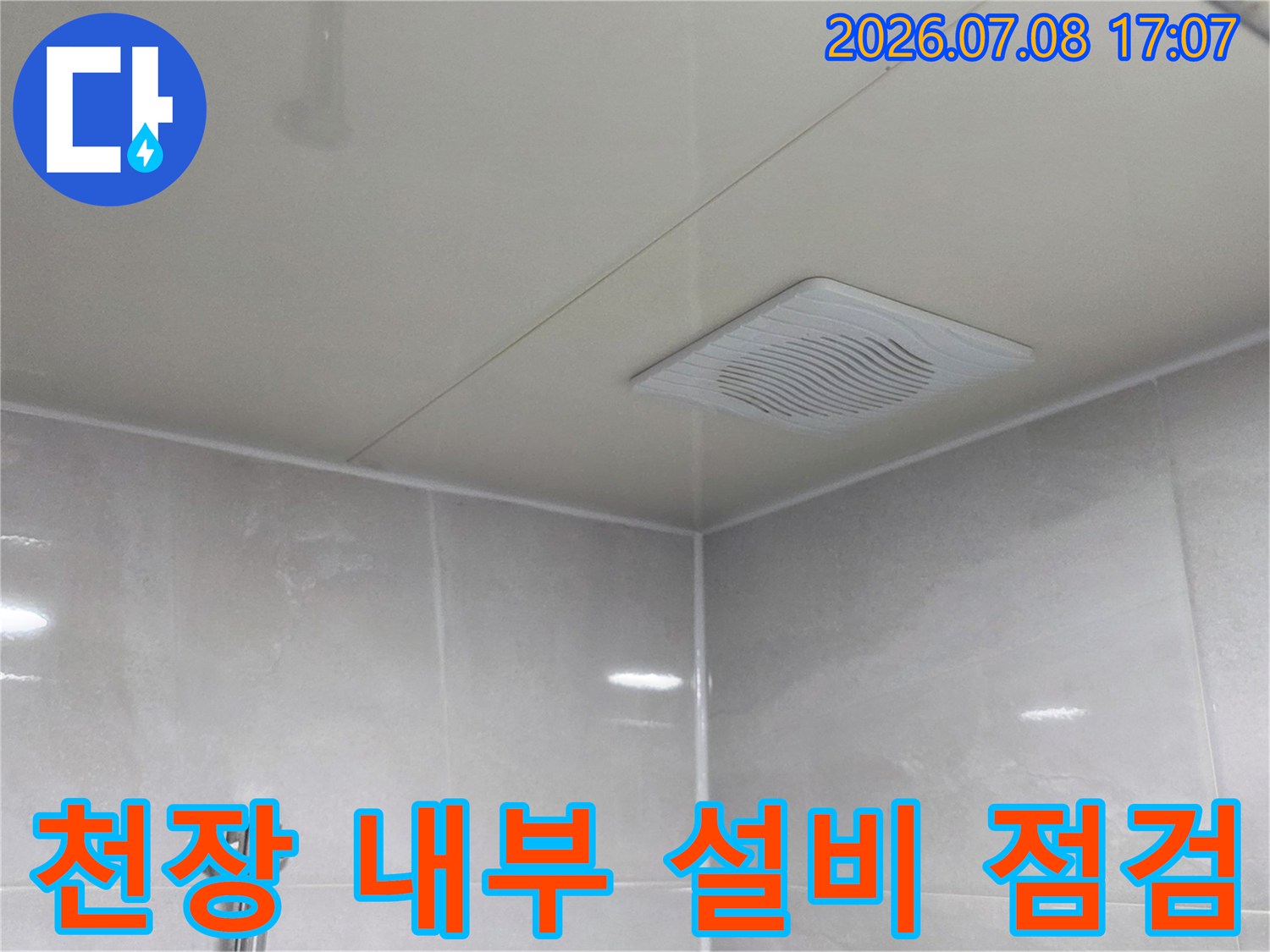 화장실 천장의 배관 연결 부위와 환풍기 주변 공간의 누수 여부를 면밀하게 확인하는 모습