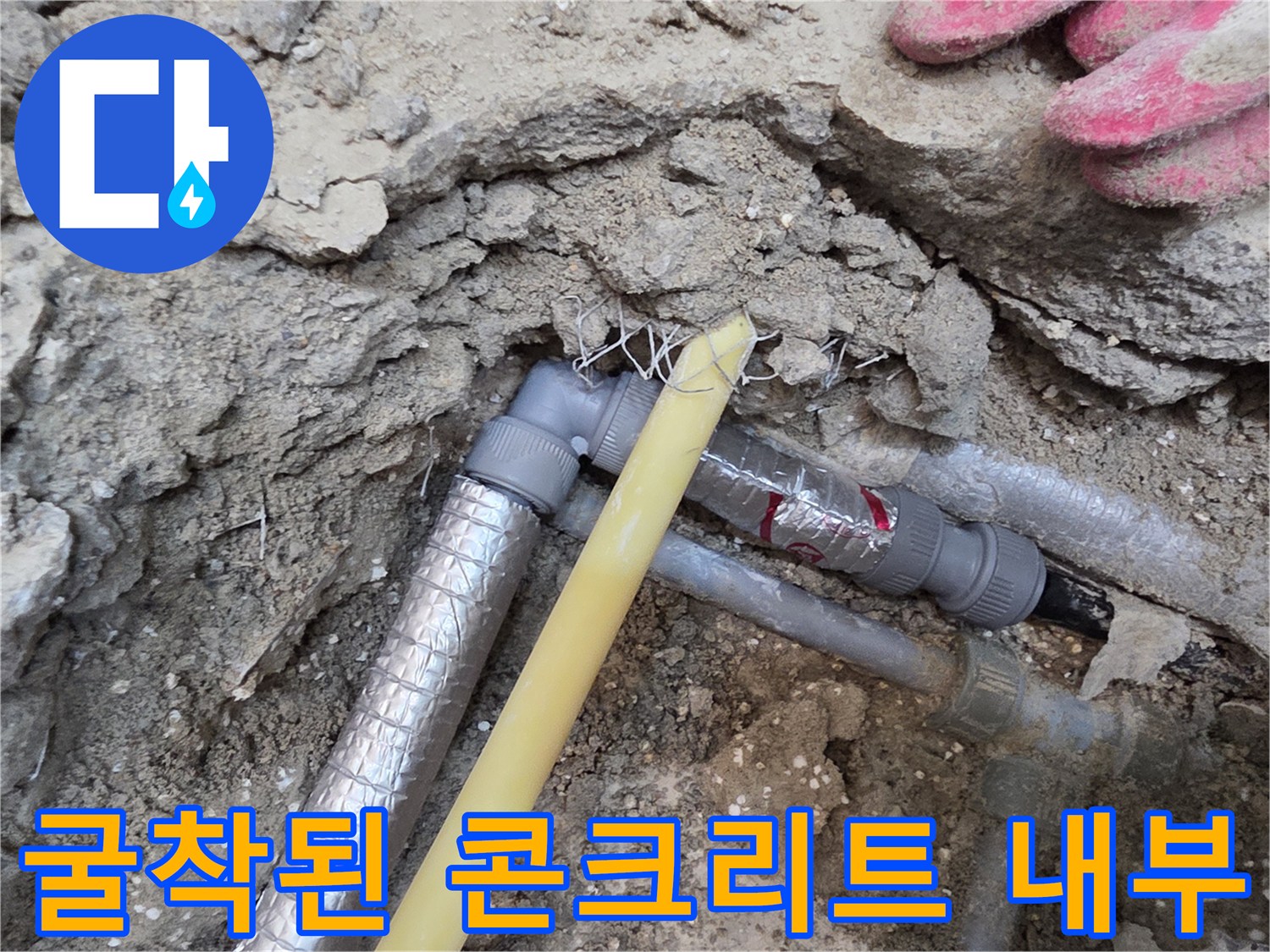 콘크리트 층을 제거하여 드러난 배관 연결 부위와 흙 상태