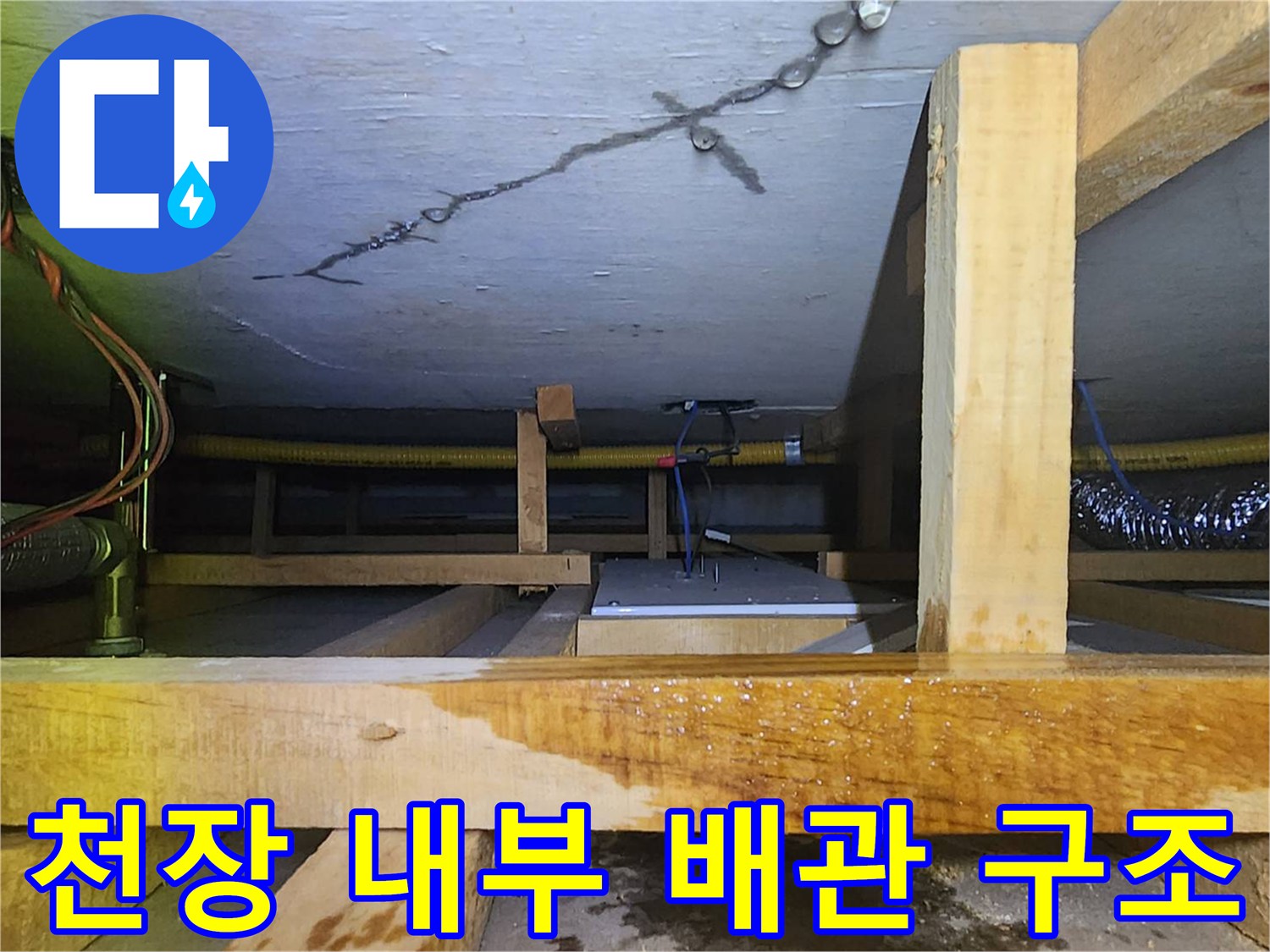 목재 구조물 사이로 보이는 배관 및 천장 마감재의 변색된 모습