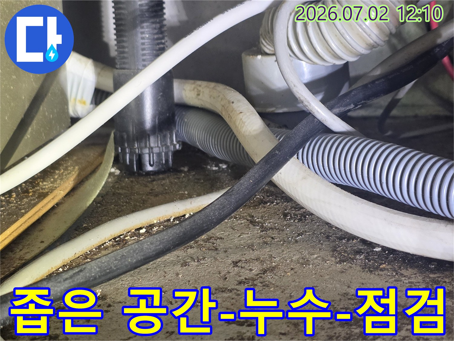 이 이미지는-좁고 복잡한-공간 속에서-누수 여부를-점검하는-모습을 담고 있습니다.